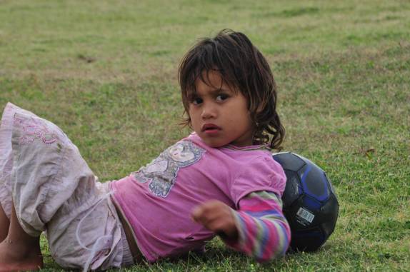 Criança se diverte com bola na praia de Anakena, em Rapa Nui (ou Ilha de Páscoa), ilha chilena no meio do Oceano Pacífico